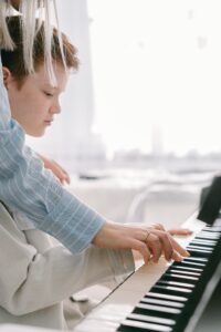 menino tocando teclado musical
